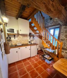 uma cozinha com armários brancos e uma escada numa casa em Maison d'hôtes et gîte au Manoir de la Haute Pilais em Chantepie