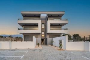 ein großes weißes Gebäude mit einem Parkplatz in der Unterkunft Mina stunning sea view apartment in Novalja