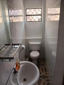 een witte badkamer met een toilet en een wastafel bij Annodas Homes Milimani Kisumu in Kisumu