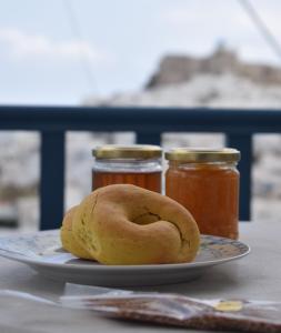 a plate with a bagel and two jars of honey at Castelli Studios in Astypalaia