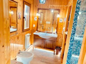 baño de madera con lavabo y aseo en CicloPark Morano Calabro, en Morano Calabro