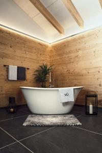 bañera en una habitación con pared de madera en VÜ Terrassen-Chalets, en Münchberg