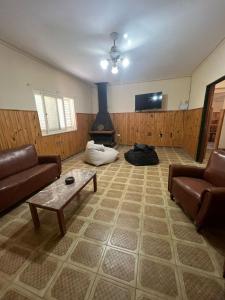 a living room with a couch and a table and a fireplace at Amplia Quinta Familiar en Sauce Viejo in Sauce Viejo