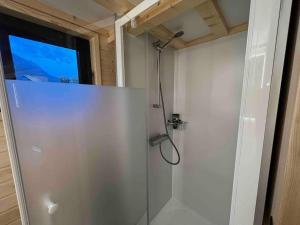 a shower stall in a bathroom with a window at Tiny House nähe Millstättersee gemütlich & autark in Oberkolbnitz