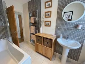 a bathroom with a sink and a mirror at Beautiful 2 bedroom apartment with estuary views in Deganwy