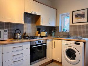 a kitchen with a washing machine and a washer at Beautiful 2 bedroom apartment with estuary views in Deganwy