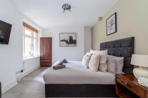 a bedroom with a large bed with white sheets and pillows at The Maida Vale Flat in London