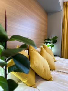 a bed with yellow pillows and a plant on it at Bulgarane House in Govedartsi