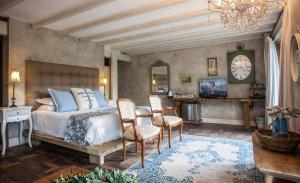 1 dormitorio con cama, sillas y reloj en Petite Provence B&B en Ballito