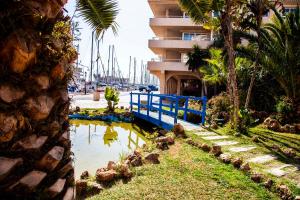 a body of water next to a building with palm trees at Expoholidays - Puerto Deportivo La Goleta in Almerimar