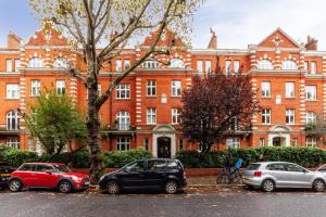 a large brick building with cars parked in front of it at The Maida Vale Flat in London