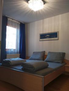 a bedroom with a bed with blue pillows and a window at Zen Apartman in Budakalász