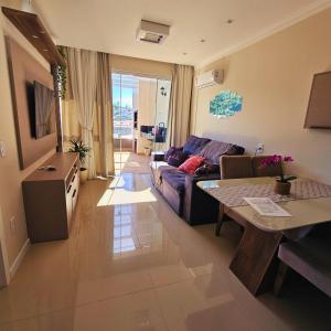 a living room with a couch and a table at Cobertura em Bombinhas - Piscina - Luxo - Alto Padrão in Bombinhas
