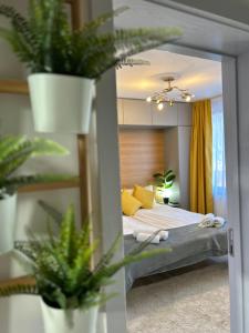 a bedroom with a bed with yellow pillows and plants at Bulgarane House in Govedartsi