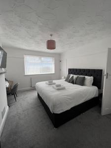 a bedroom with a large bed and a window at 3 Bed Residential home - 5 mins from M4 in Port Talbot