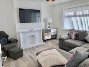 a living room with a couch and a fire place at 3 Bed Residential home - 5 mins from M4 in Port Talbot