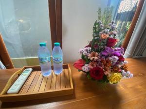 due bottiglie d'acqua e un telecomando su un tavolo di GUS ARDITYA HOMESTAY ad Ubud