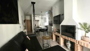 a living room with a black couch and a fireplace at Disfruta Madrid Atocha in Madrid