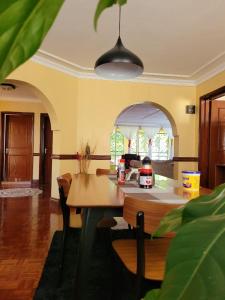a dining room with a table and chairs in a room at Annodas Homes Milimani Kisumu in Kisumu