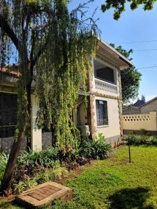 een huis met een boom ervoor bij Annodas Homes Milimani Kisumu in Kisumu