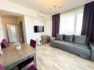 uma sala de estar com um sofá e uma mesa em BlueSea Summerland Apartments em Mamaia
