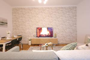 een woonkamer met een bakstenen muur en een open haard bij Emerald holiday home with patio in Wenen