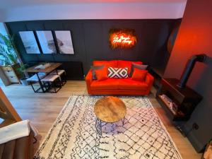 a living room with a red couch and a table at Hot Tub, King Bed, Central, Modern Beach House in Cleethorpes