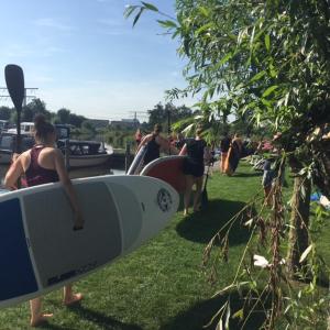 a group of people holding surfboards on the grass at Camping Pasveer 