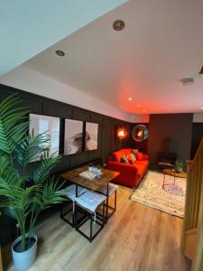 a living room with a red couch and a table at Hot Tub, King Bed, Central, Modern Beach House in Cleethorpes