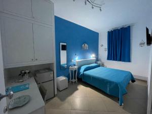 Dormitorio azul con cama y lavamanos en B&B Le Onde Del Mare, en Gallipoli