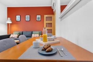 RECENTLY RENOVATED 2 BEDROOM APARTMENT IN EIXAMPLE في برشلونة: طاولة مع طبق من الطعام وكأس من عصير البرتقال