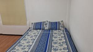 a bed with blue and white sheets and pillows at OHiggins 1087 in Iquique