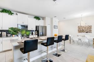 eine Küche mit weißen Schränken und einem Tisch und Stühlen in der Unterkunft Resort Style, close to Disney and other parks in Davenport