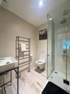 a bathroom with a toilet and a sink and a shower at Kensington Apartments in London