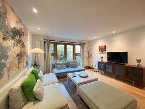 a living room with a couch and a tv at Kensington Apartments in London