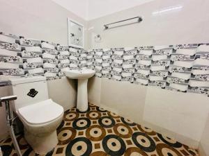 a bathroom with a toilet and a sink at JM Suites in Tezpur