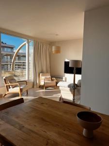 ein Wohnzimmer mit einem Sofa und einem Tisch in der Unterkunft Appartement Sainte-Cécile in De Panne