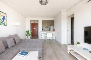 ein Wohnzimmer mit einem Sofa und einem Tisch in der Unterkunft Apartamento amplio con 4 habitaciones y 2 baños - Great apartment with 4 rooms - 2 baths in Sevilla