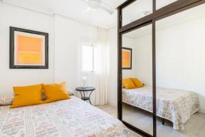 sypialnia z 2 łóżkami i lustrem w obiekcie Apartamento amplio con 4 habitaciones y 2 baños - Great apartment with 4 rooms - 2 baths w Sewilli
