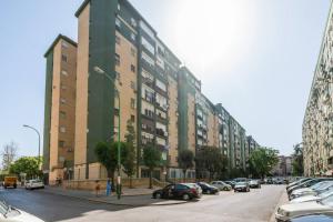 ein großes Gebäude mit Autos auf einem Parkplatz in der Unterkunft Apartamento amplio con 4 habitaciones y 2 baños - Great apartment with 4 rooms - 2 baths in Sevilla