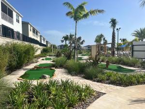 ダベンポートにあるBeautiful home, inside the best resort in Orlando!の人工芝とヤシの木があるゴルフコース