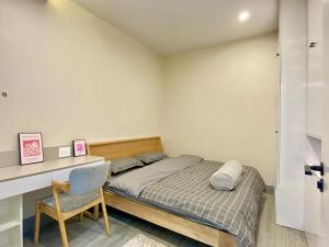 1 dormitorio con cama, escritorio y silla en G-space apartment, en Hai Phong