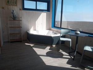 Cabaña con jacuzzi campo mar في ماتانزاس: حمام مع حوض وطاوله وكرسي