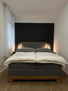 a bedroom with a large bed with a black headboard at TOKA ROOMS - an der Regiobahn in Mettmann