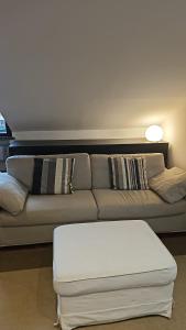 a living room with a couch with a white ottoman at 108 APARTMENT - Torino in Turin