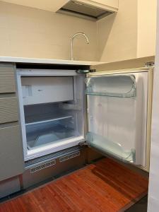 an empty refrigerator with its door open in a kitchen at 108 APARTMENT - Torino in Turin