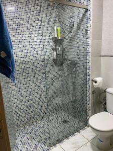 La salle de bains est pourvue d'une douche en verre et de toilettes. dans l'établissement Apparemment TAMARIS, à Dar Bouazza