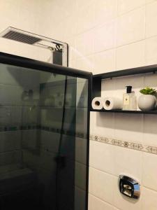 een douche met een glazen deur in de badkamer bij Bertioga Casa pertinho da Praia in Bertioga