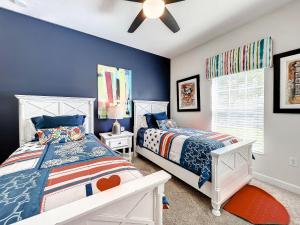 - une chambre avec 2 lits et un ventilateur de plafond dans l'établissement Stunning 5 bedroom house near Disney, à Davenport
