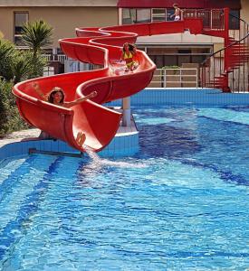un grupo de personas en un tobogán de agua en una piscina en Serena Majestic Residence, en Montesilvano